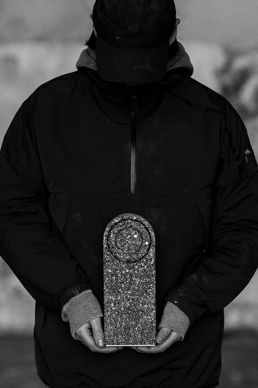 Studio Michael McCready From Foam to Dust Table Clock held in the hand of a dark figure presumably the creator of the art