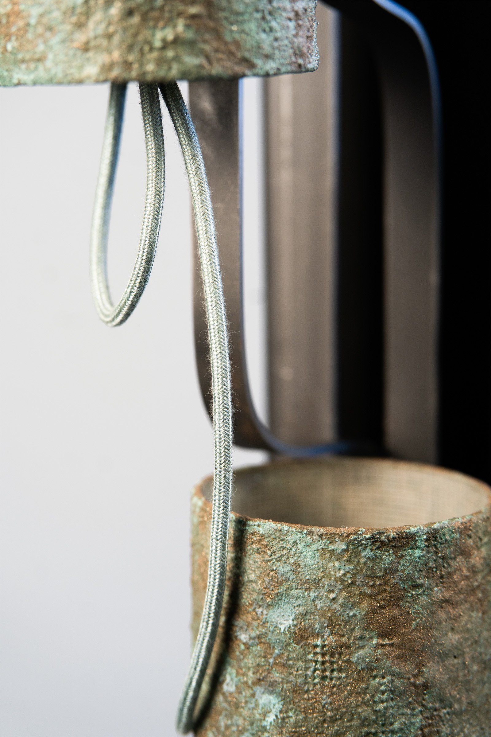 Closeup of lampshades that look like natural green stone and green textile cable