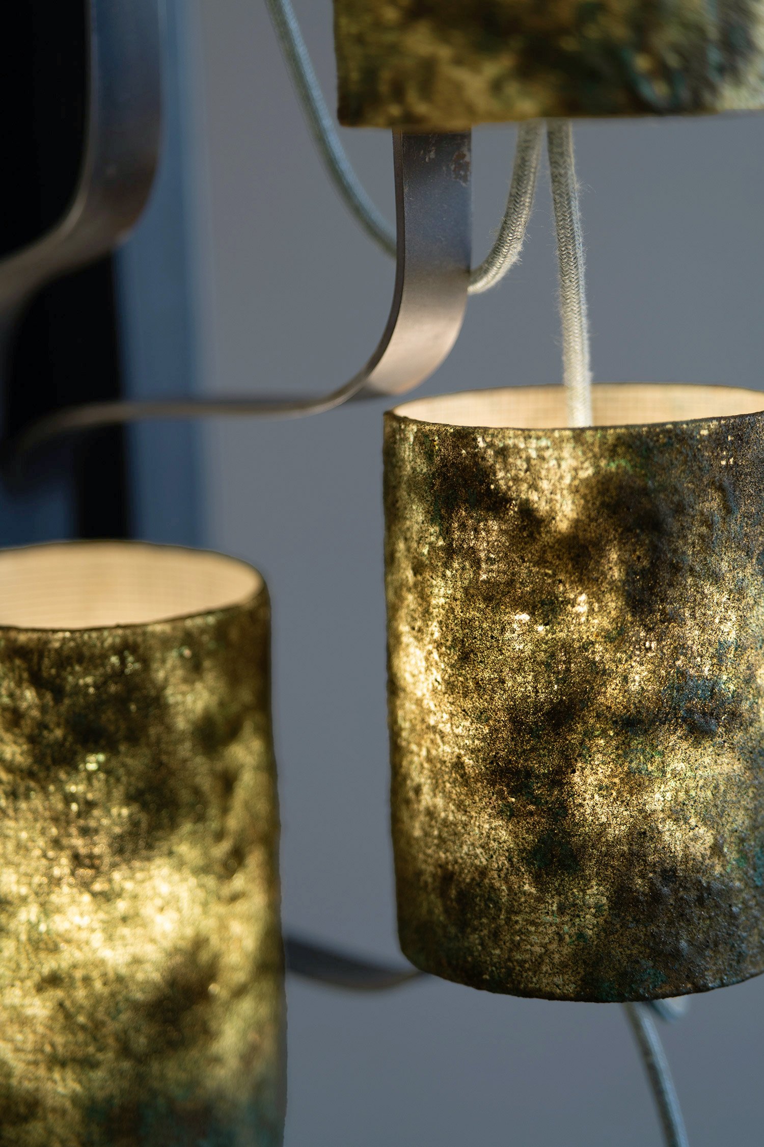 Closeup of natural green stone style lampshades with lights on and textile cable